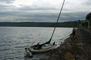 Zeilboot die vastgelopen is voor de kust